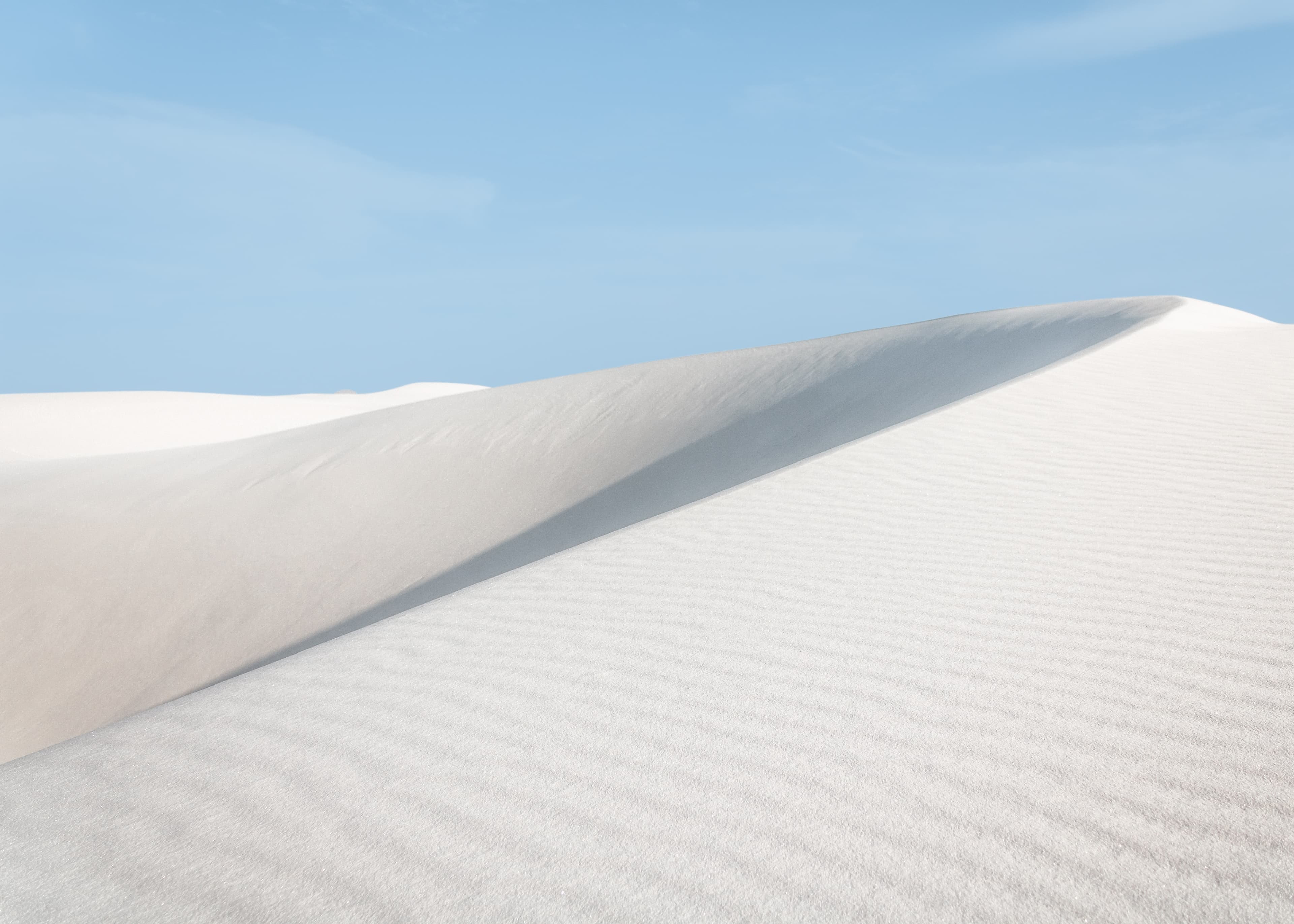 White sand dunes under a clear blue sky